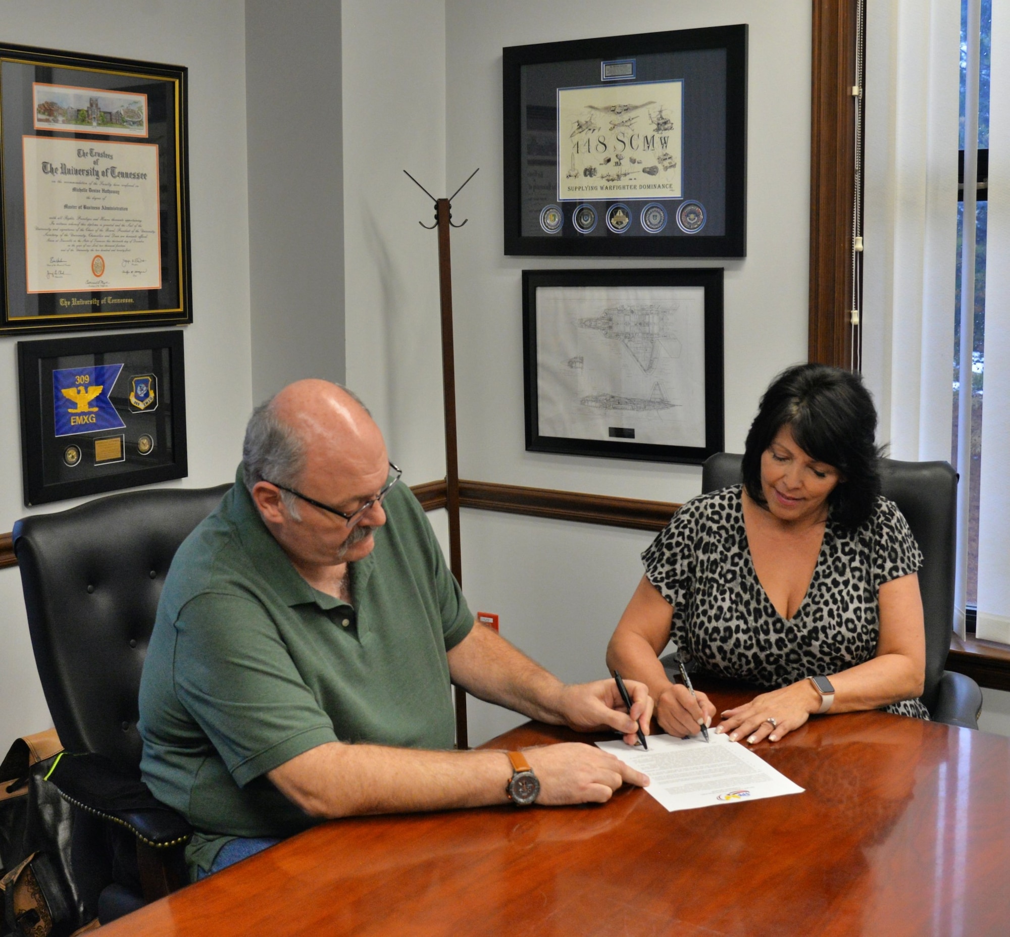 Michelle Hathaway, Ogden Air Logistics Complex vice director, and Jeffery Langston, AFGE 1592 Local Union president, sign the OO-ALC VPP Commitment Agreement.  The agreement renewed the OO-ALC’s commitment to promote employee empowerment, quality of life, increased work quality and efficiencies and military readiness.