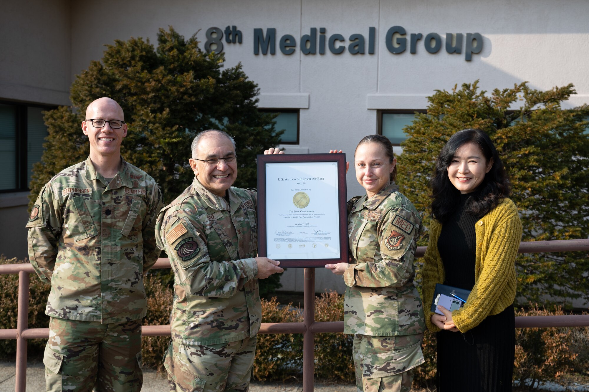 Leaders with the 8th Medical Group take a group photo with a The Joint Commission (TJC) certificate at Kunsan Air Base, Republic of Korea, Jan. 18, 2023. The TJC inspection evaluates a medical facilities safety procures, training levels and records for all doctors, nurses and technicians, equipment quality and patient care. (U.S. Air Force photo by Staff Sgt. Sadie Colbert)