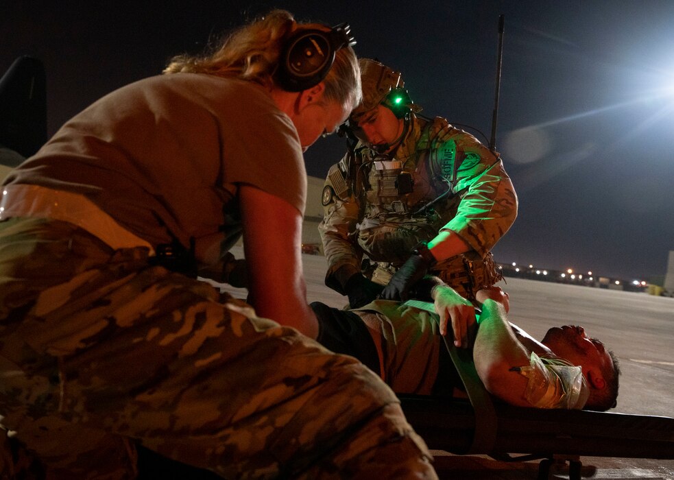 A photo of airmen carrying a litter with a simulated patient on it