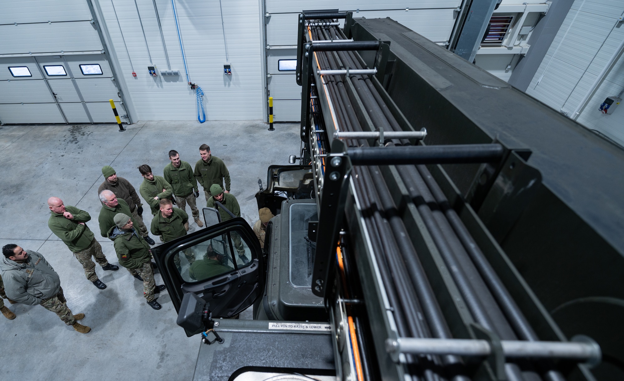 Airmen assigned to the 435th Contingency Response Support Squadron, teach Lithuanian personnel assigned to the Terminal Operations Squadron how to conduct vehicle inspections at Šiauliai Air Base, Lithuania, Jan. 17, 2023. During Global ER-2875 de-icer maintenance and inspections, machinery is checked for wear and tear, flaws, or faults. These issues are then repaired to prevent breakdowns and downtime, saving time and money.  (U.S. Air Force photo by Airman 1st Class Edgar Grimaldo)