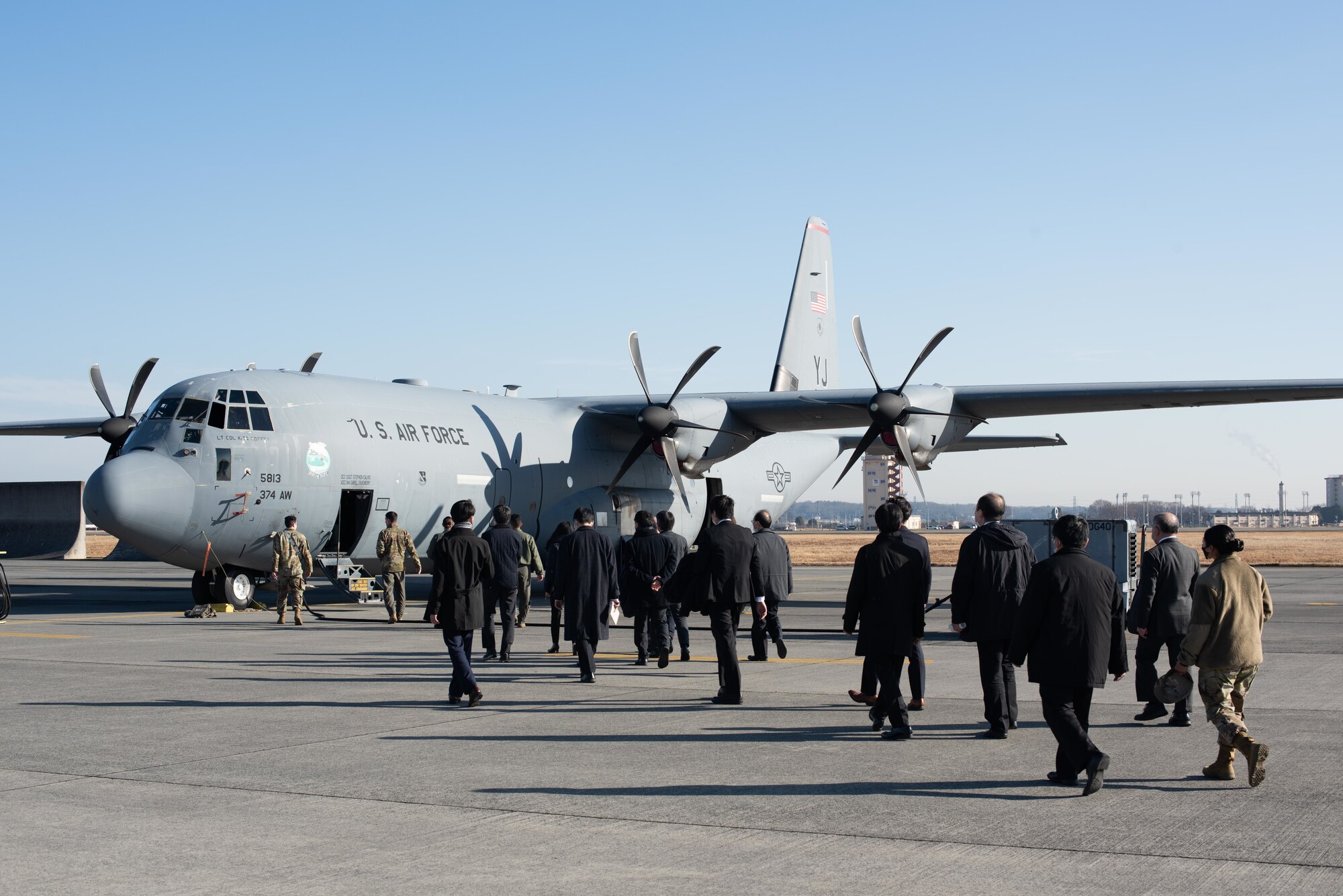 twenty people walk towards a large cargo aircraft