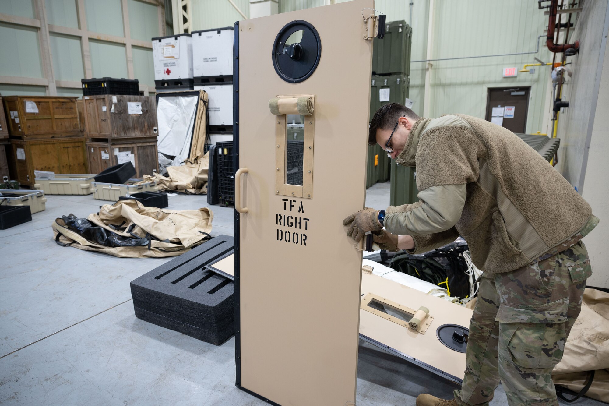 Staff Sgt. Nick Kozak, 8th Healthcare Operations Squadron NCO in charge of contingency support, adjusts the hinges of a toxic-free area door entrance at Kunsan Air Base, Republic of Korea, Jan. 20, 2023. The tent kit 2 chemical protection system is composed of two rooms—a multi-functional entrance and a toxic-free area. (U.S. Air Force photo by Senior Airman Akeem K. Campbell)