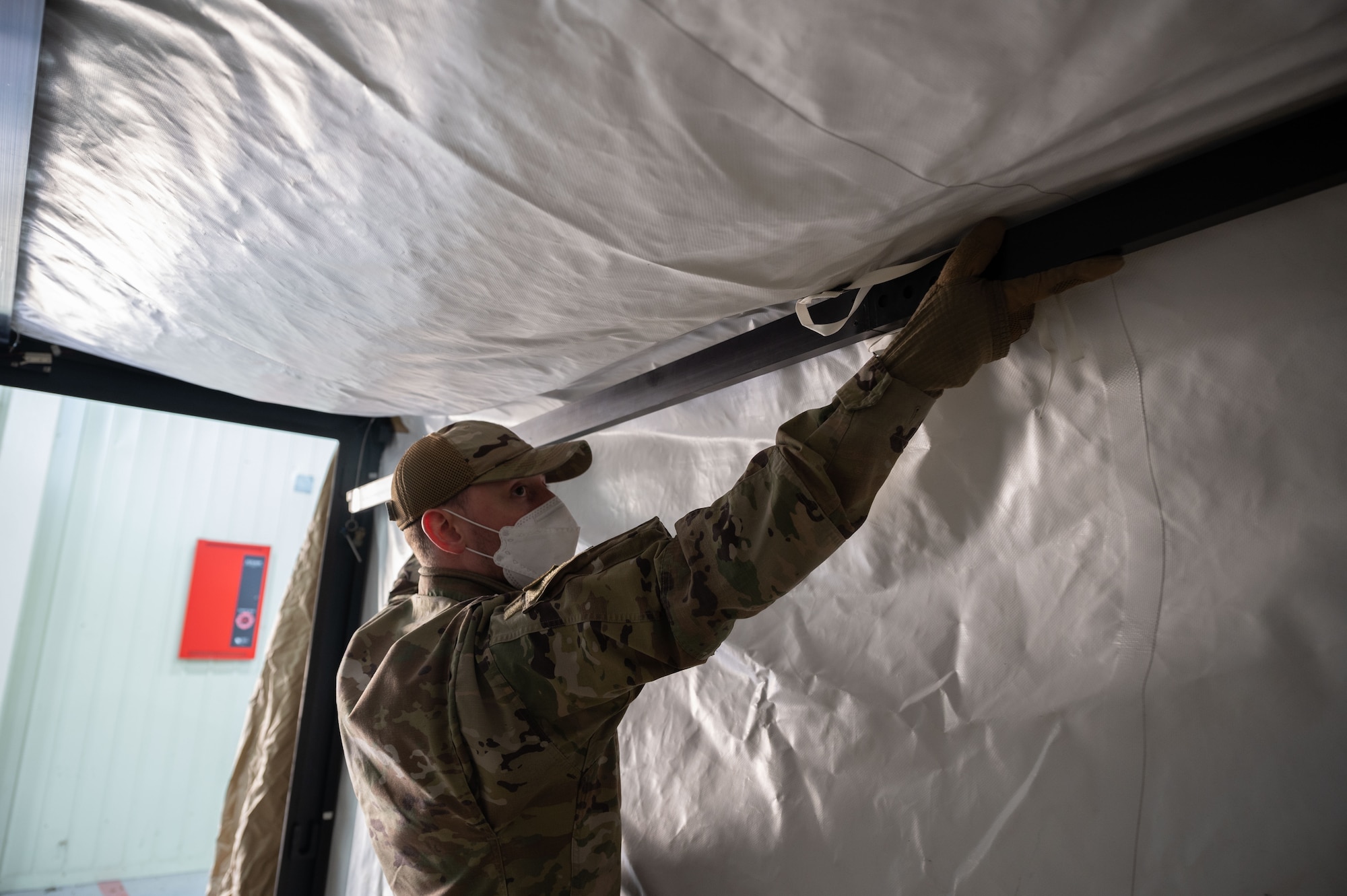 Senior Airman Brett Fetterman, 8th Healthcare Operations Squadron (HCOS) war reserve materiel technician, holds up a frame inside the multi-functional entrance of a chemical protection system (CPS) at Kunsan Air Base, Republic of Korea, Jan. 20, 2023. The 8th HCOS Airmen built and deconstructed the tent kit 2 CPS three times under the guidance of the Airmen from Eielson Air Force Base, Alaska. (U.S. Air Force photo by Senior Airman Akeem K. Campbell)