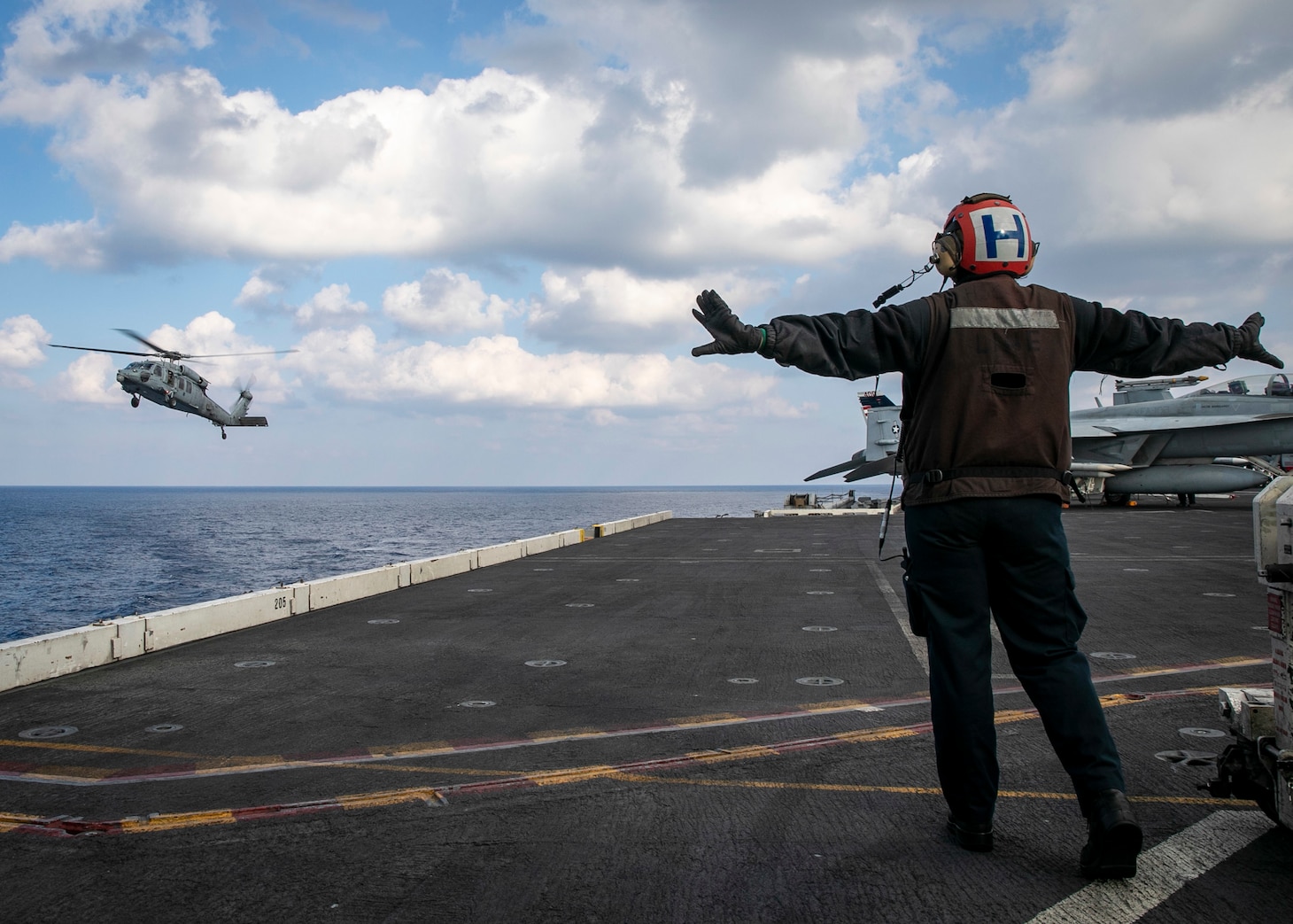 Airman Estefany Rodriguezvegas, assigned to the Nimitz-class aircraft carrier USS George H.W. Bush (CVN 77), directs an MH-60S Nighthawk helicopter, attached to Helicopter Sea Combat Squadron (HSC) 5, from the flight deck Jan. 23, 2023.