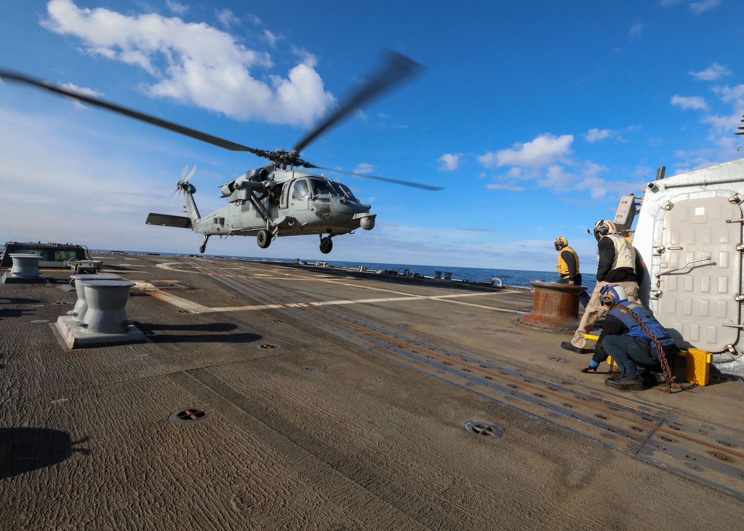 An MH 60S Nighthawk helicopter, attached to Helicopter Sea Combat Squadron Five (HSC) 5, lands on the flight deck of the Arleigh Burke-class guided-missile destroyer USS Bulkeley (DDG 84), Jan. 12, 2023.