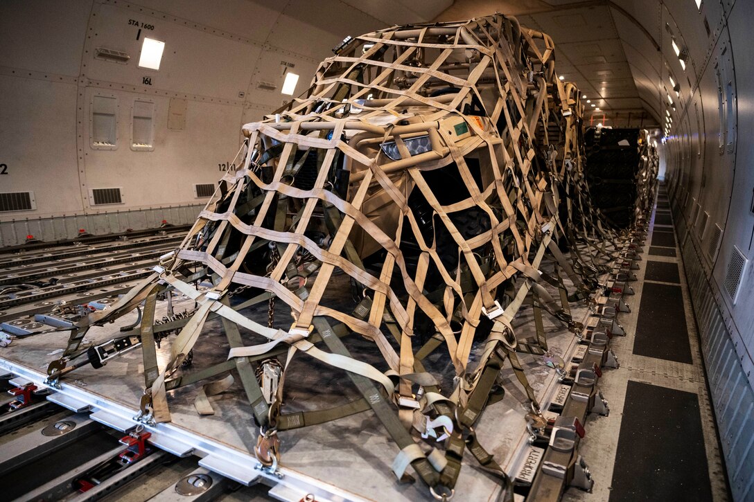 Tactical vehicles are secured inside an aircraft.