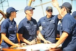 U.S. Coast Guard Barque Eagle crewmembers and Coast Guard Academy officer candidates celebrate a job well done while navigating on the bridge of the Eagle Sept. 17, 2012. Officer candidates from the Academy spend two weeks of their 17-week training aboard Eagle to improve their seamanship, teamwork and leadership skills. (U.S. Coast Guard photo by Petty Officer 1st Class Lauren Jorgensen)
