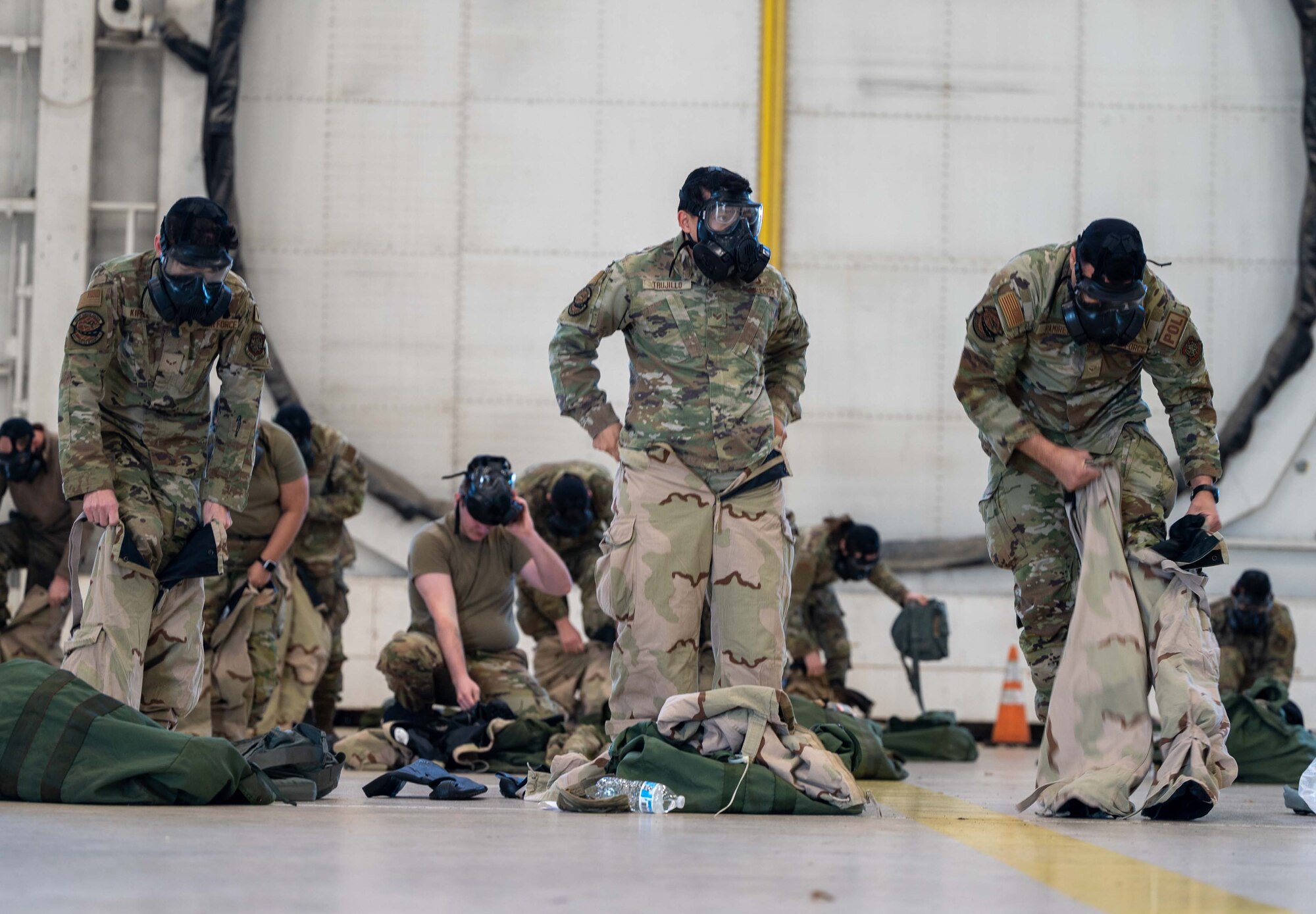Airmen from the 436th Logistic Readiness Squadron put on Mission-Oriented Protective Posture (MOPP) gear during a 436th MGG Integration Event at Dover Air Force Base, Delaware, Jan. 20, 2023. This event is the first of monthly readiness exercises that test the ability to perform job tasks in contested environments. (U.S. Air Force Photo by Senior Airman Faith Barron)