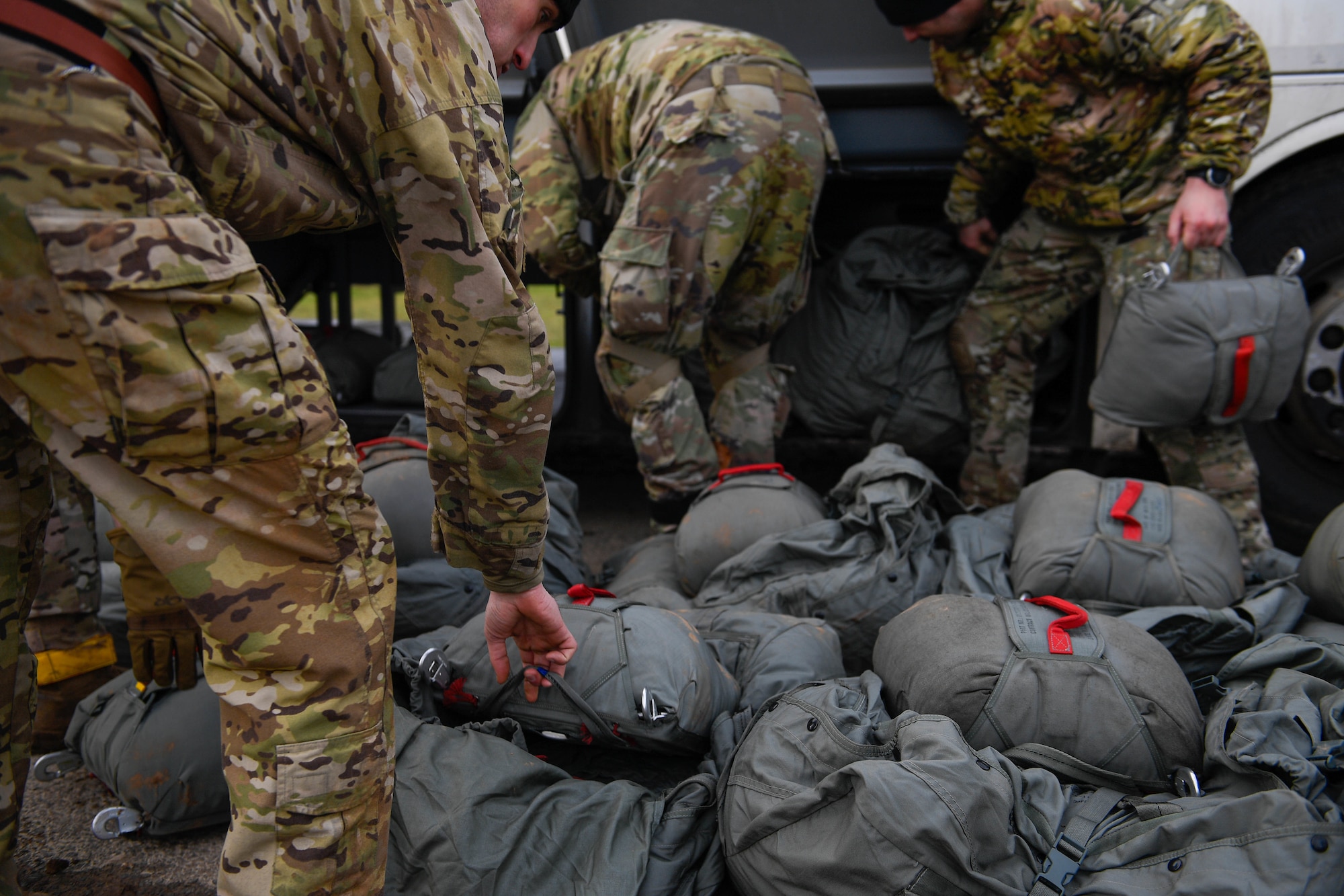U.S. Air Force paratroopers from the 435th Contingency Response Group pack their parachutes into a bus after jumping into the Alzey Drop Zone in Ober-Flörsheim, Germany, Jan. 20, 2023.
