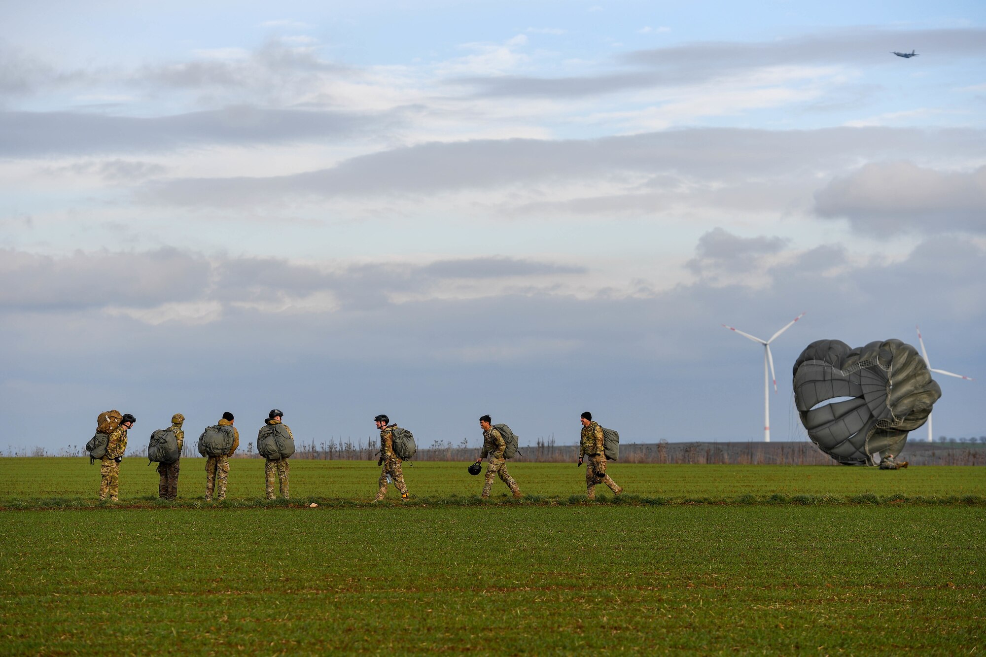 U.S. Air Force paratroopers with the 435th Contingency Response Group, based at Ramstein Air Base, Germany, gather together after their jump into the Alzey Drop Zone in Ober-Flörsheim, Germany, Jan. 20, 2023.