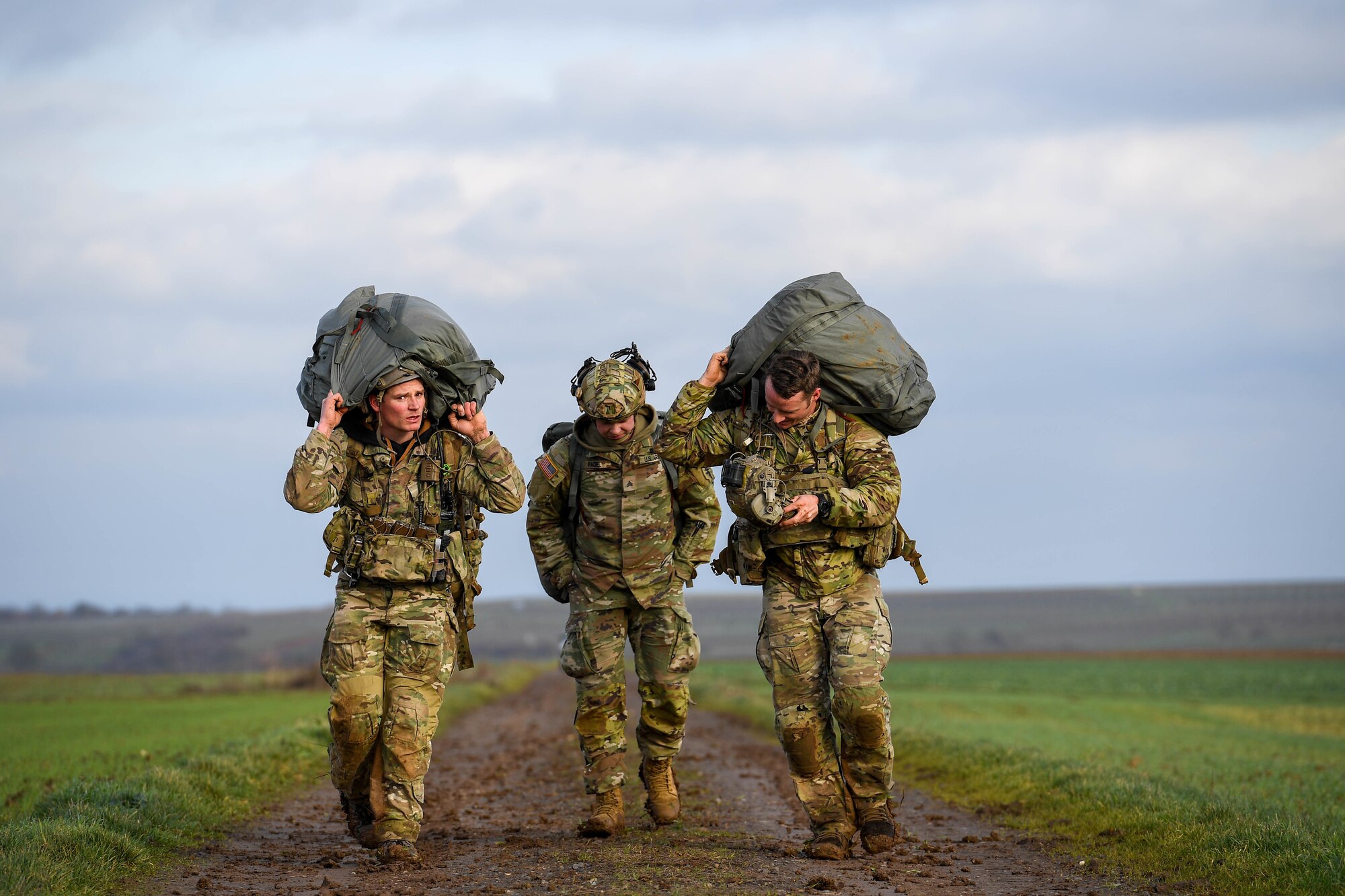 U.S. Army paratroopers from the 173rd Airborne Brigade and the 1st Battalion, 10th Special Forces Group, carry their gear after a jump into Alzey Drop Zone in Ober-Flörsheim, Germany, Jan. 20, 2023.