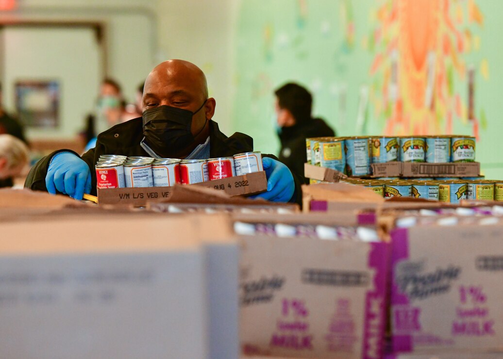 Brian Lindsey, a member of Naval District Washington’s (NDW) N1 team, packs canned goods into boxes while volunteering at the Capital Area Food Bank in Washington.