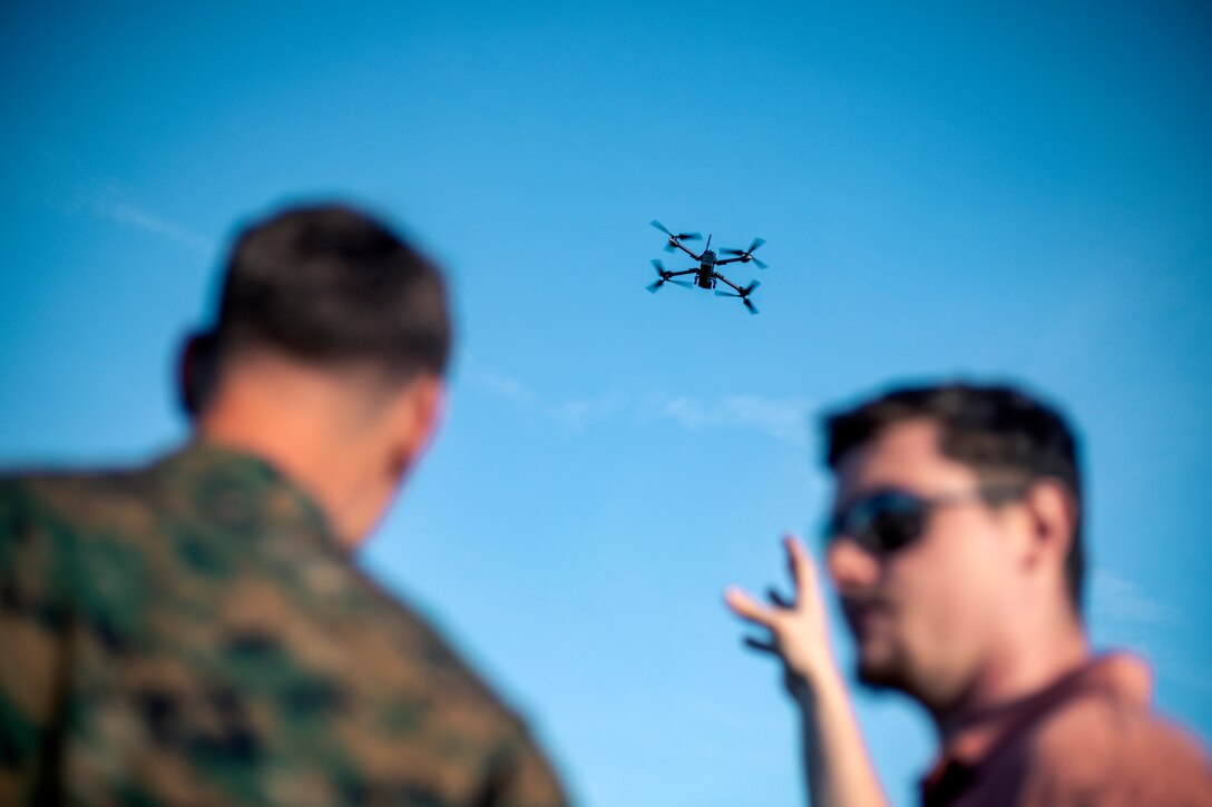 Two men fly a drone.