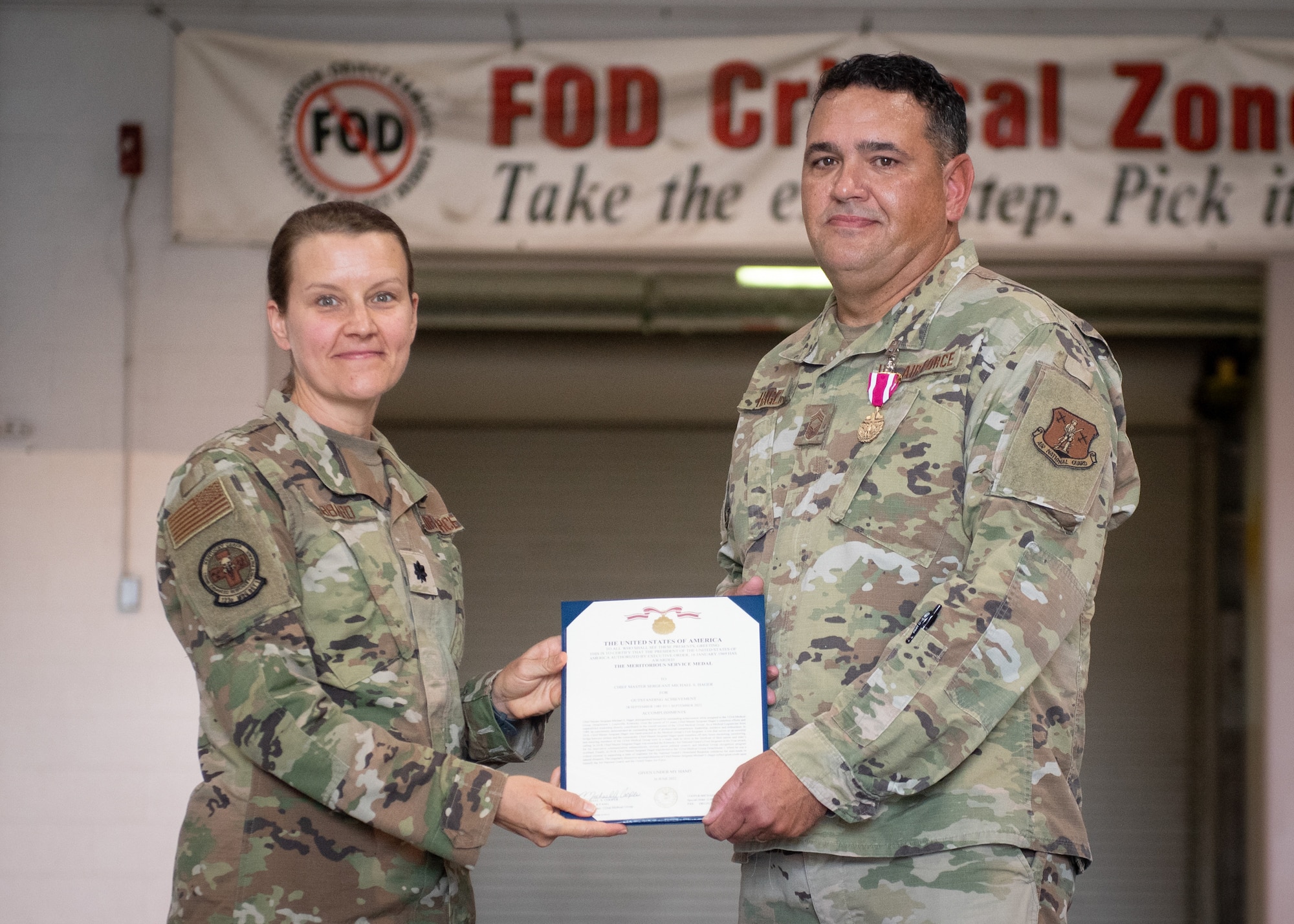 Lt. Col. Tiffany Hubbard, left, commander of 123rd Medical Group Detachment 1, presents Chief Master Sgt. Michael S. Hager, 123rd MDG Det. 1 non-commissioned officer in charge, with the Meritorious Service Medal during his retirement ceremony at the Kentucky Air National Guard Base in Louisville, Ky., Sept. 10. 2022. Hager enlisted in 1989 and spent the entirety of his 33-year career with the Kentucky Air Guard. (U.S. Air National Guard photo by Staff Sgt. Clayton Wear)