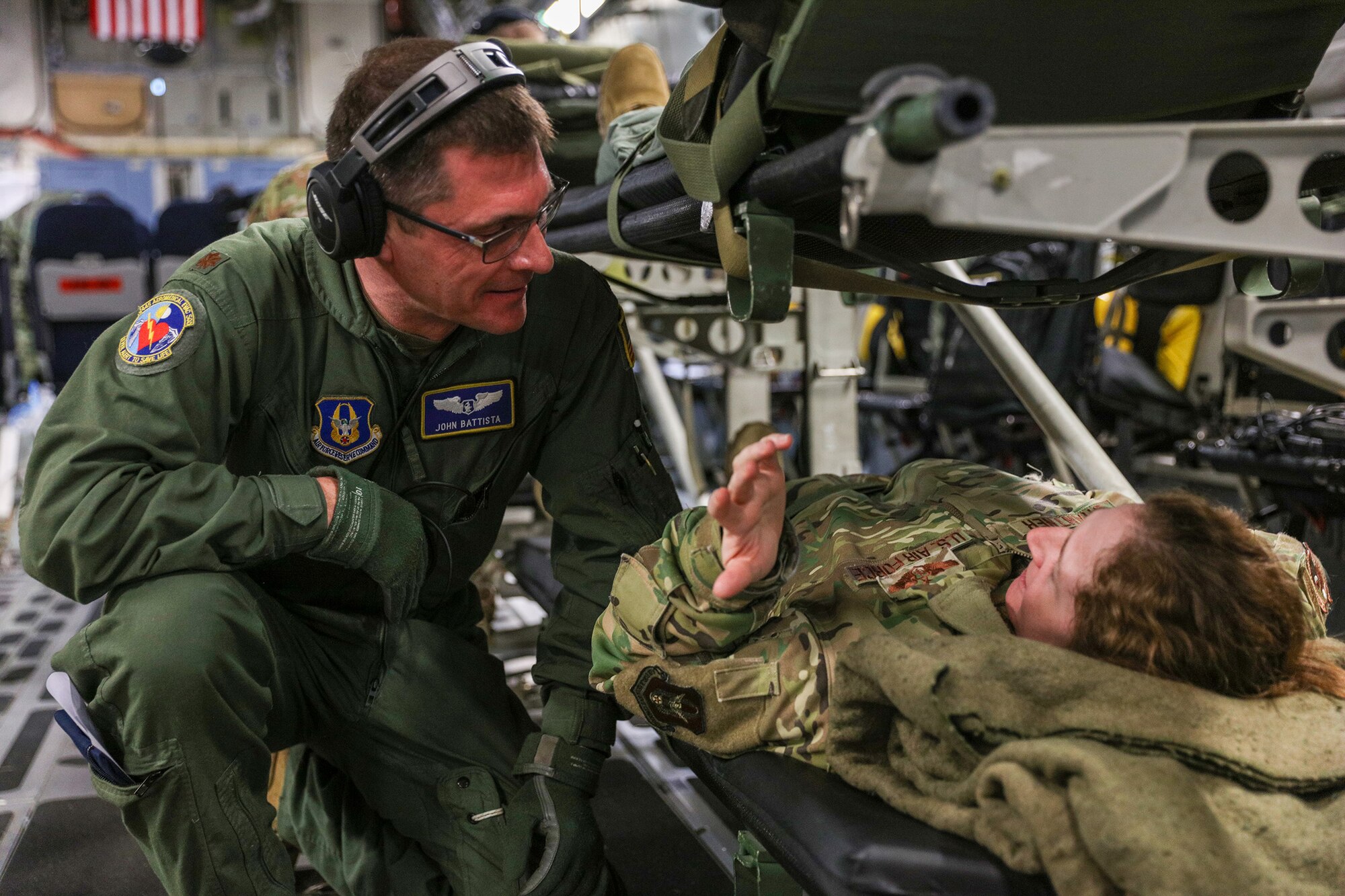 Maj. John Battista, 445th Aeromedical Evacuation Squadron flight nurse, checks on a “patient” played by Lt. Col. Jessica Brantner, 445th AES flight nurse, during a medical training scenario onboard a C-17 Globemaster III Jan. 20, 2023. The AE flight was part of the 445th Airlift Wing training event held in San Diego, California Jan. 18-23. Over 150 Reservists from the 445th Airlift Wing, to include 445th Aeromedical Evacuation Squadron, 445th Aerospace Medicine Squadron, 445th Operations Support Squadron, 445th Maintenance Group, 445th Aircraft Maintenance Squadron, 445th Maintenance Squadron, 87th Aerial Port Squadron and 89th Airlift Wing provided support or participated in the training event that included water survival, AES training flights and urban survival, evasion, resistance and escape.