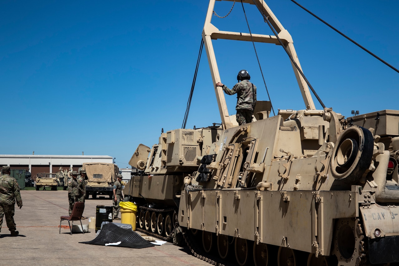Soldiers work on tactical vehicles.