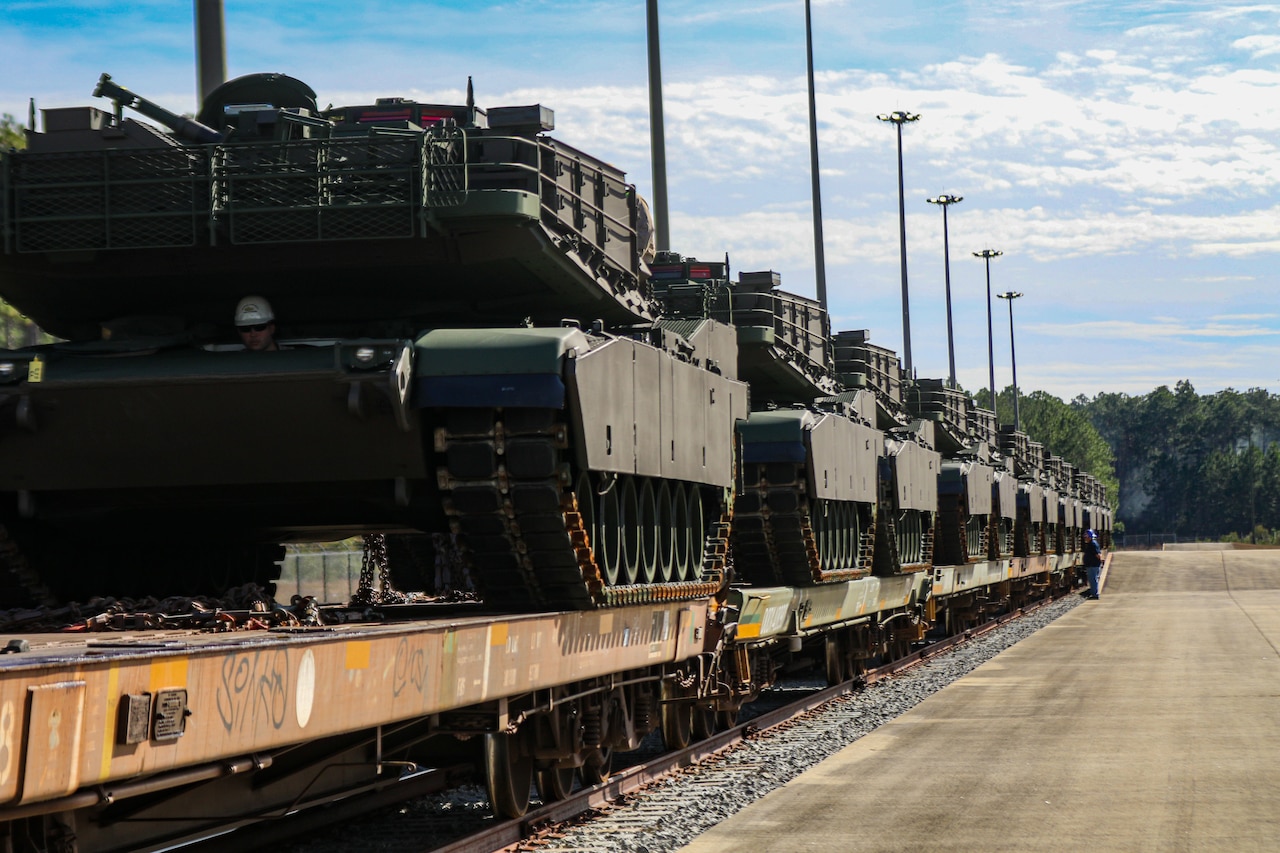 Tanks sit atop railcars.