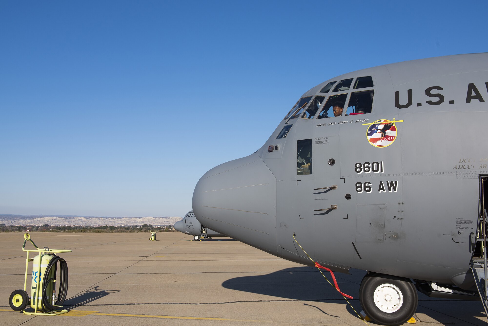 A man is shown in the window of a grey plane