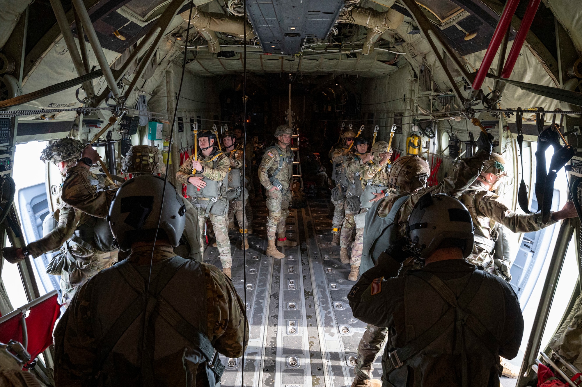 Airmen and Soldiers prepare to perform a static-line jump from a C-130J Super Hercules.