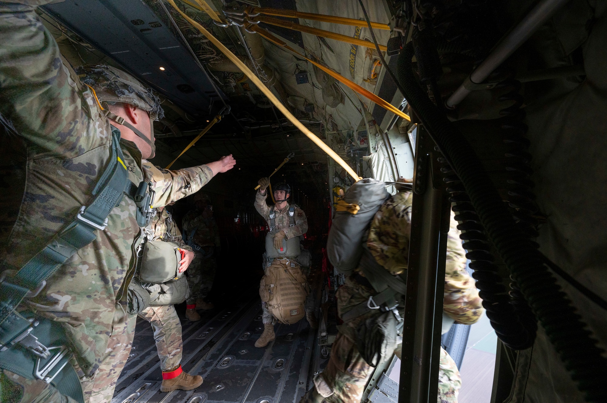 Airmen prepare to perform a static-line jump from a C-130J Super Hercules.