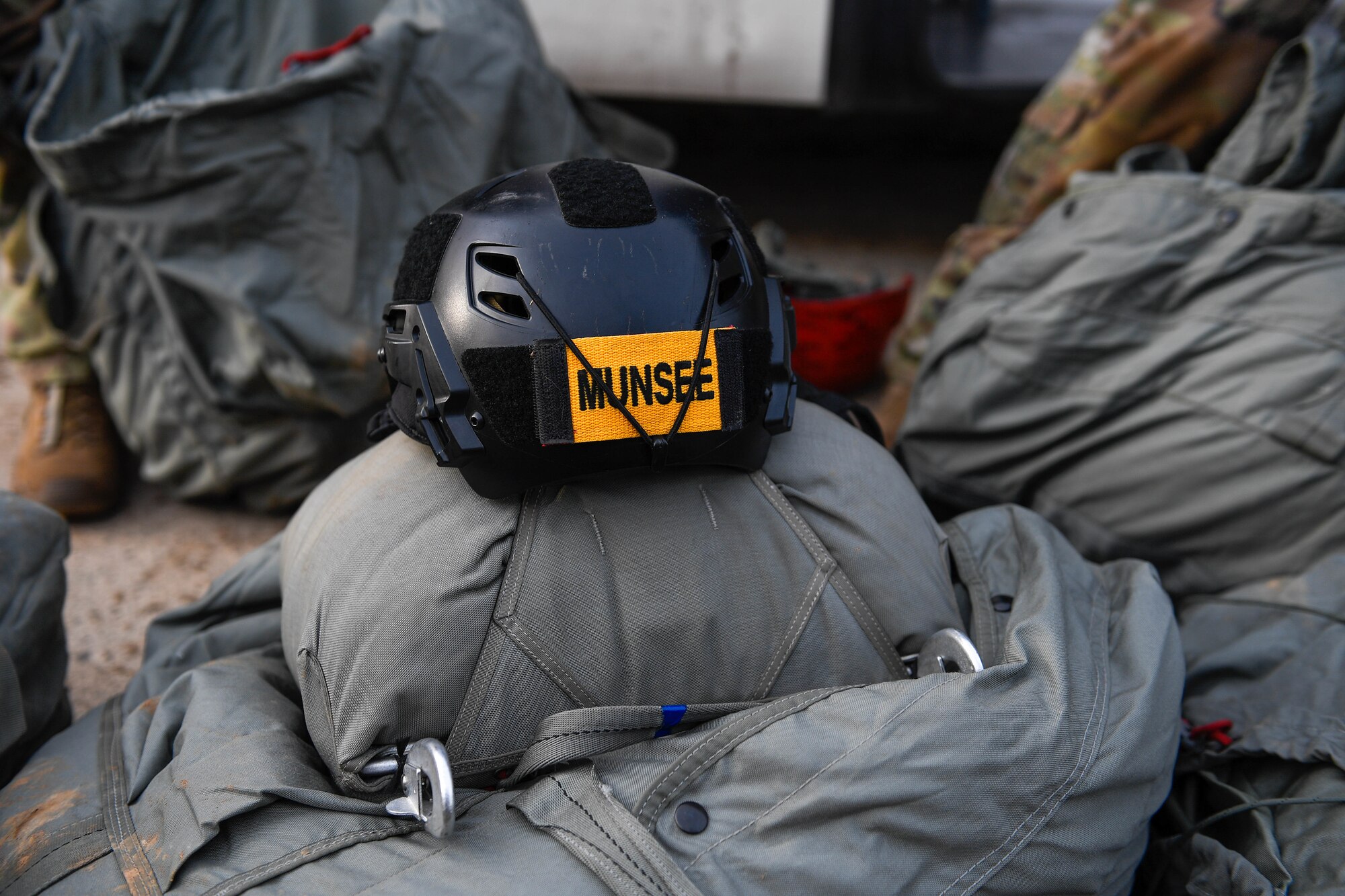 A helmet from U.S. Air Force Tech. Sgt. Lance Munsee,  435th Contingency Response Group master rated jumpmaster, sits on a parachute bag at Alzey Drop Zone in Ober-Flörsheim, Germany, Jan. 20, 2023.