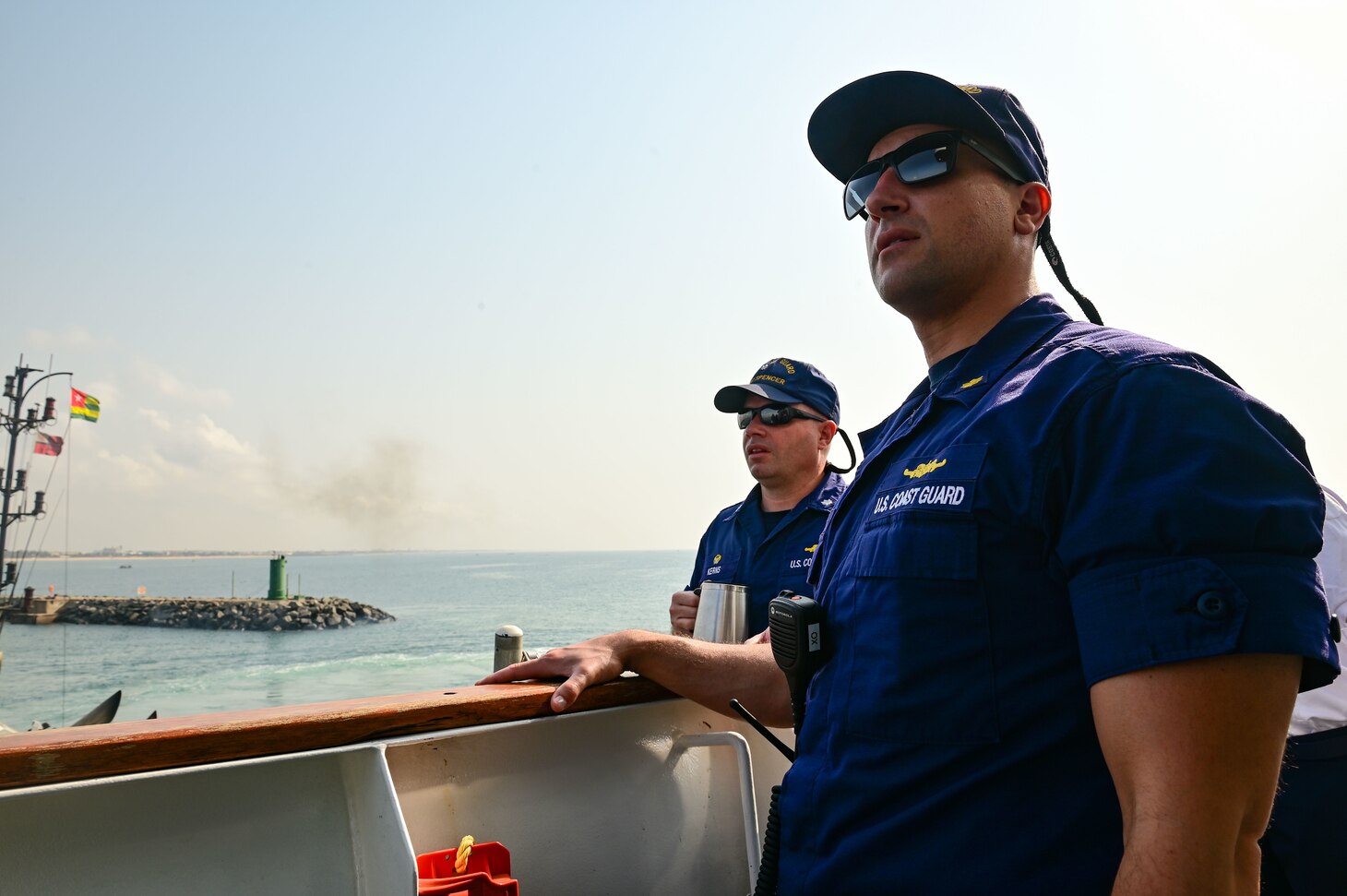 Cmdr. Corey Kerns, commanding officer, and Lt. Cmdr. Nicholas Forni, executive officer of USCGC Spencer (WMEC 905), supervise from the bridge as the cutter moors in Lomé, Togo Jan. 25, 2023.