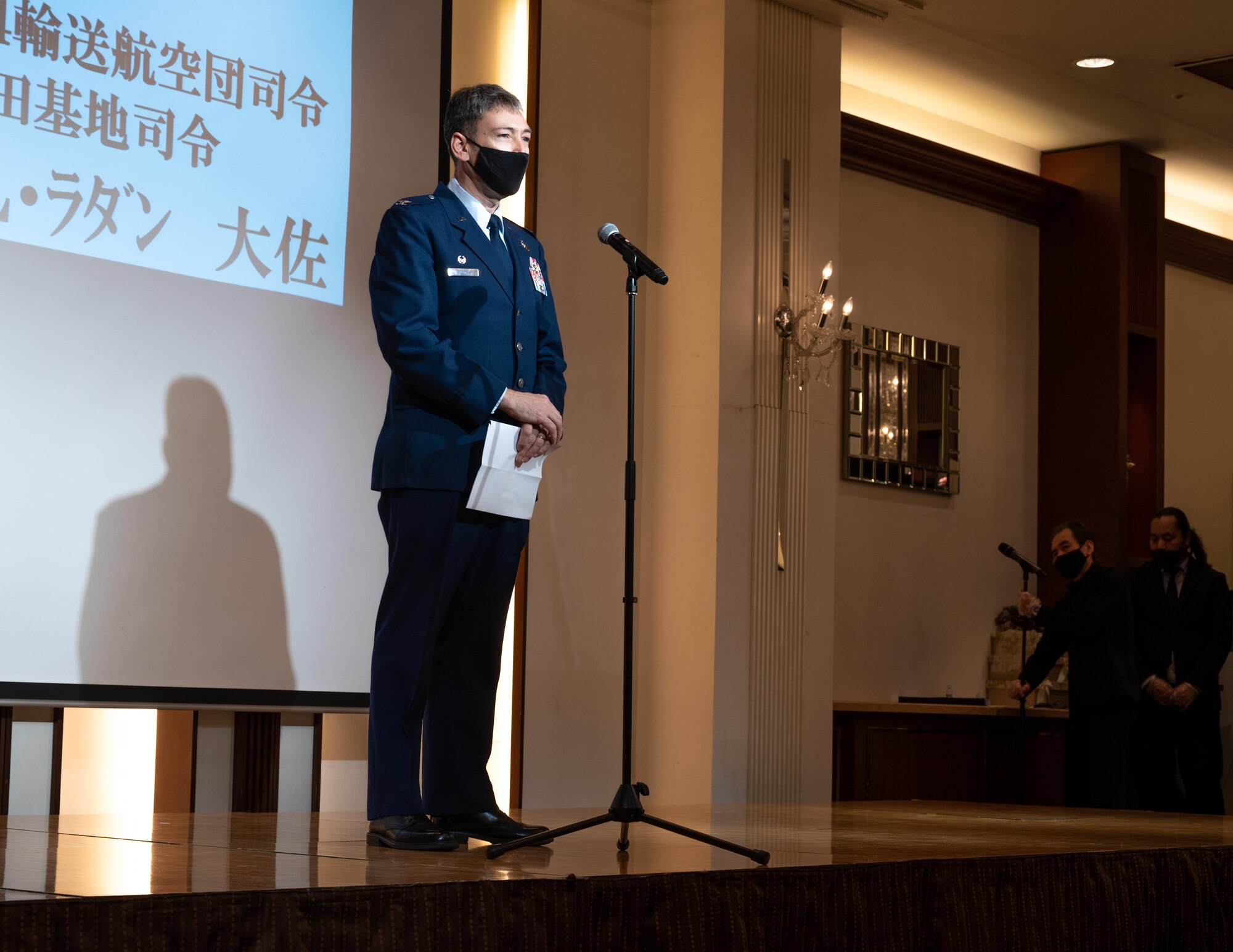 Col. Andrew Roddan speaks on stage with a microphone.
