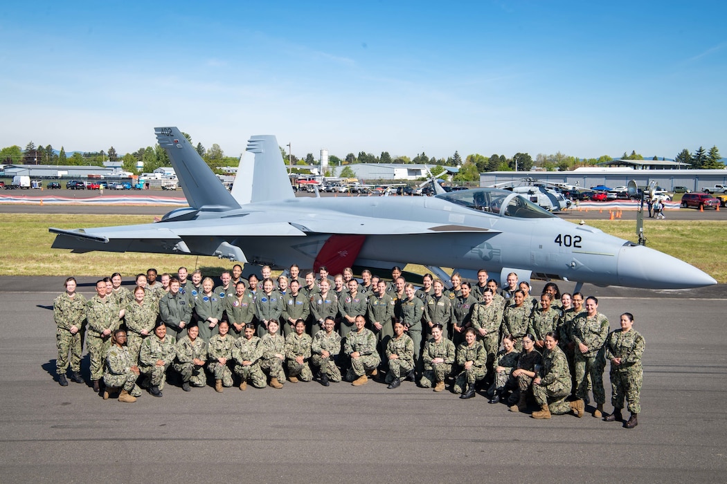 U.S. Naval aviators, aircrew and maintenance teams pose for a photograph in front of an F/A-18E Super Hornet assigned to the “Fist of the Fleet” Strike Fighter Squadron (VFA) 25 at the 2022 Oregon International Air Show in Hillsboro, Oregon, May 22, 2022.