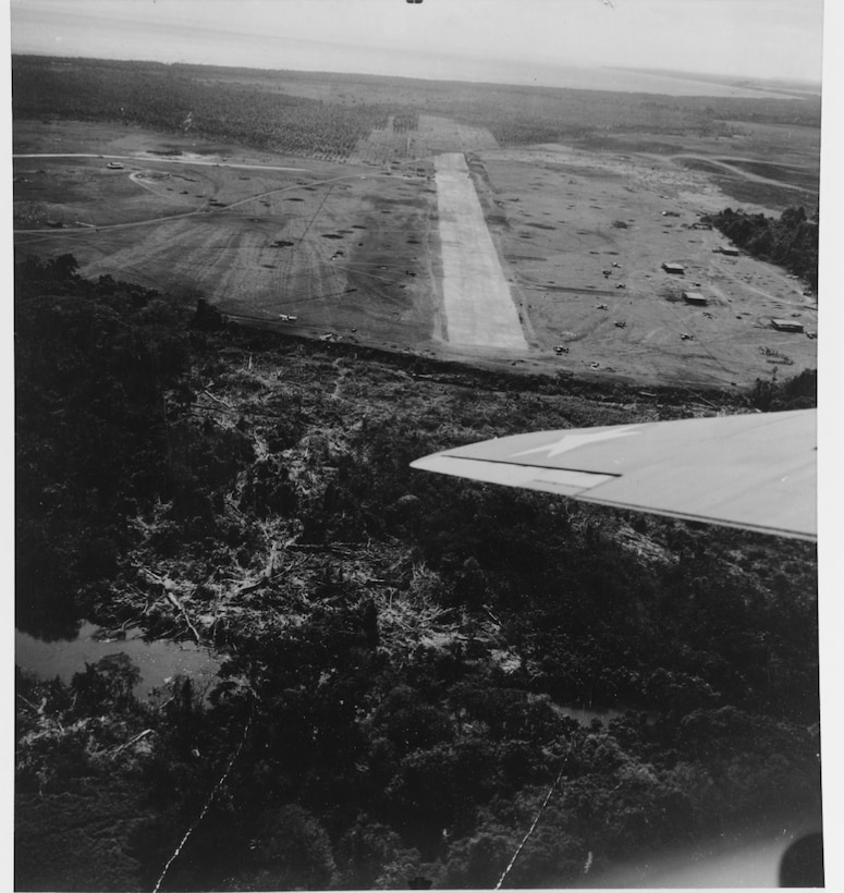 Henderson Field looking southeast, 22 August 1942. Buildings to south of runway “were intended for shops. They have 7/8 inch steel roofs.” Planes on field are F4Fs. (NHHC 80-G-12216)