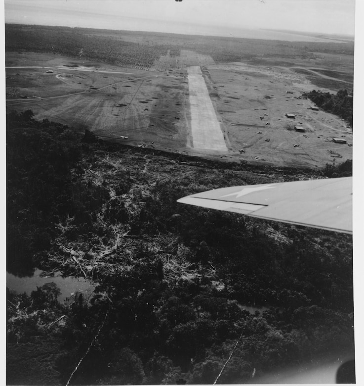 Henderson Field looking southeast, 22 August 1942. Buildings to south of runway “were intended for shops. They have 7/8 inch steel roofs.” Planes on field are F4Fs. (NHHC 80-G-12216)