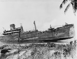 Japanese cargo ship Kyushu Maru beached and sunk on Guadalcanal in November 1942. She had been the victim of U.S. air attacks on 15 October 1942. Note wrecked Japanese landing craft in center. (80-G-K-1467-C)