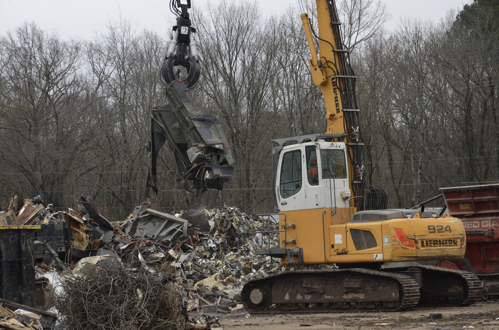 A vehicle is being held by material handling equipment.