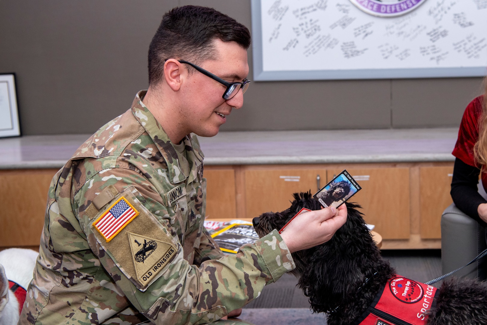 Man in military uniform pets dog