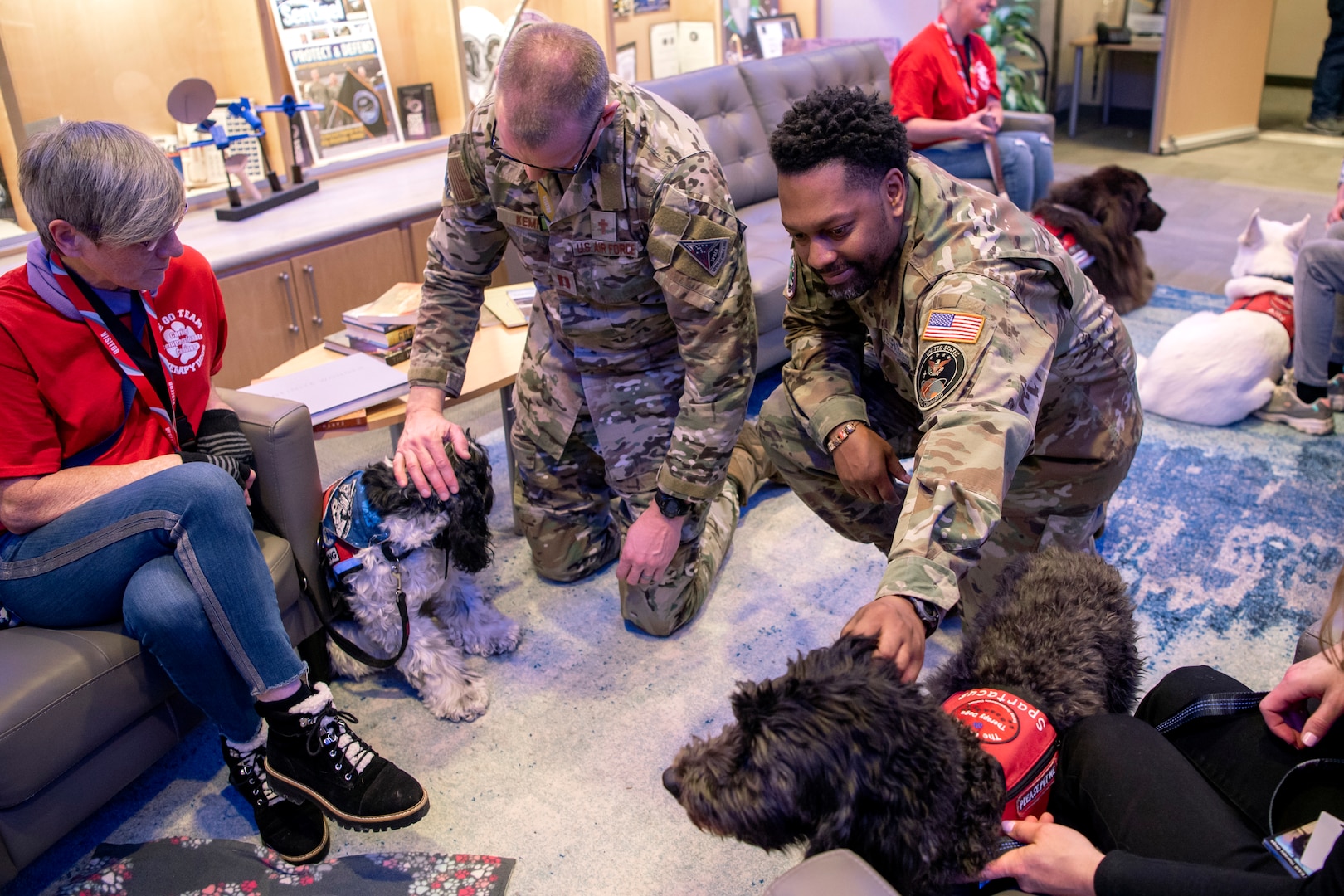 Two men in uniform pet dogs