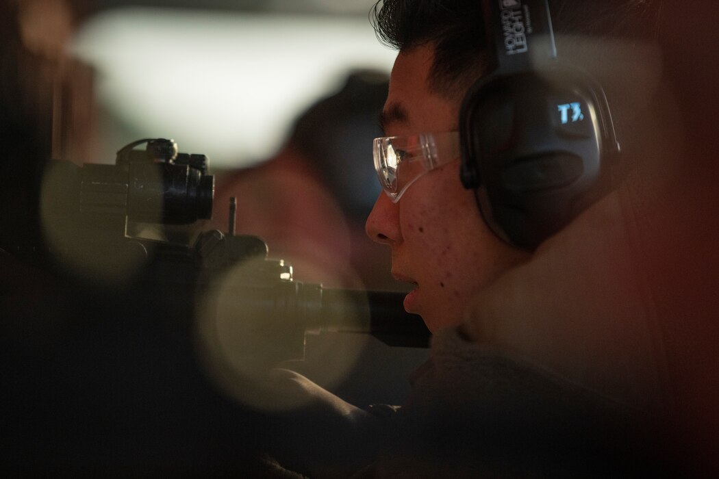 A close up image of a man taking aim down the scope of his rifle.