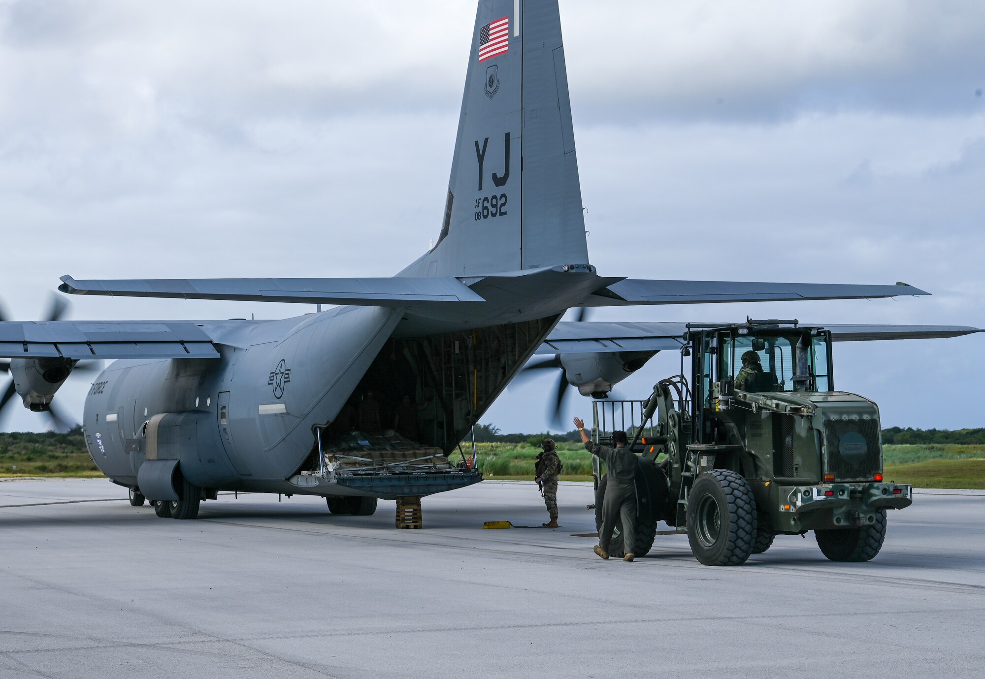U.S. Air Force Airmen unload cargo from a U.S. Air Force C-130J Super Hercules on Pacific Air Forces Regional Training Center-Andersen Air Force Base, Guam, Jan. 19, 2023. The 36th Contingency Response Group partnered with the 36th Airlift squadron from Yokota Air Base, Japan, to conduct a Field Training Exercise that tested operating in an austere environment. The units conducted a variety training scenarios such as setting up airfield/aerial ports, accomplishing drop zone operations, establishing bed down and cargo yard, bare base build-ups, communication hub and spoke operations, and securing the airbase for operation in an expeditionary environment.(U.S. Air Force photo by Airman 1st Class Allison Martin)