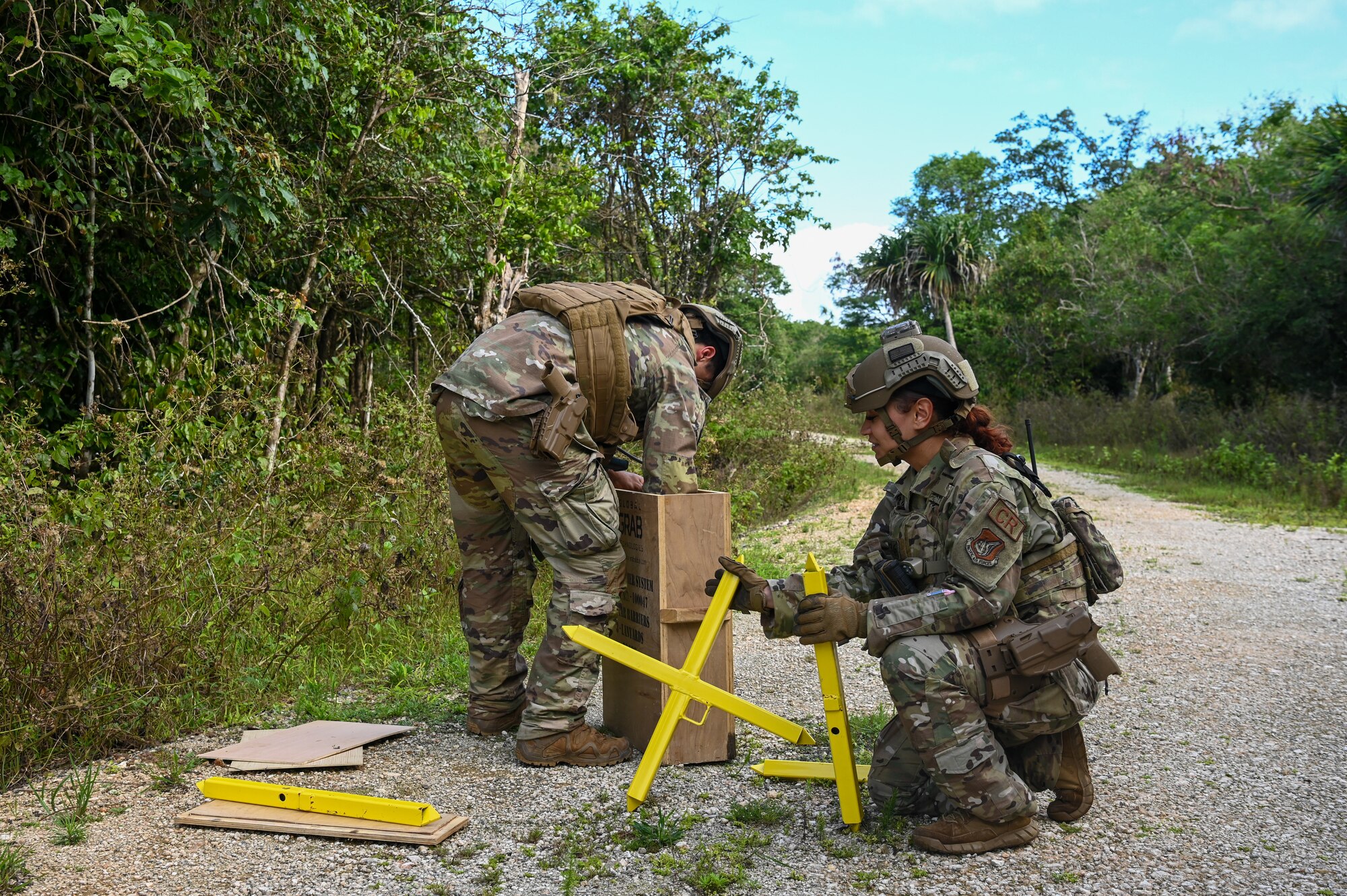 U.S. Air Force Senior Airman Anthony Bragg and U.S. Air Force Senior Airman Ashley Nieves, fire team members with the 736th Security Forces Squadron, set up road barriers on Pacific Air Forces Regional Training Center-Andersen Air Force Base, Guam, Jan. 19, 2023. The 36th Contingency Response Group partnered with the 36th Airlift squadron from Yokota Air Base, Japan, to conduct a Field Training Exercise that tested operating in an austere environment. The units conducted a variety training scenarios such as setting up airfield/aerial ports, accomplishing drop zone operations, establishing bed down and cargo yard, bare base build-ups, communication hub and spoke operations, and securing the airbase for operation in an expeditionary environment.(U.S. Air Force photo by Airman 1st Class Allison Martin)