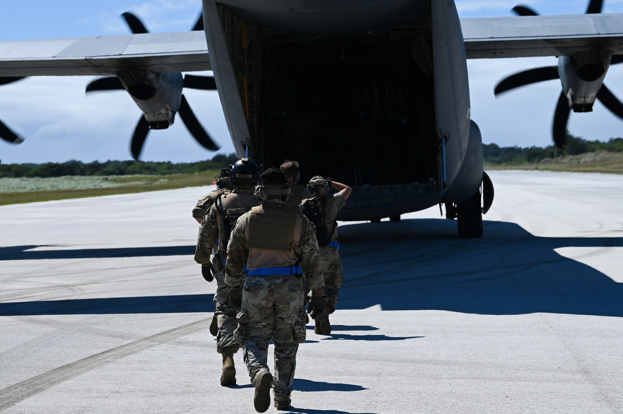 U.S. Air Force Airmen with the 734th Air Mobility Squadron walk towards a U.S. Air Force C-130J Super Hercules on Pacific Air Forces Regional Training Center-Andersen Air Force Base, Guam, Jan. 20, 2023. The 734th AMS split into small teams and performed rolling offloads of cargo during a Field Training Exercise. (U.S. Air Force photo by Airman 1st Class Allison Martin)