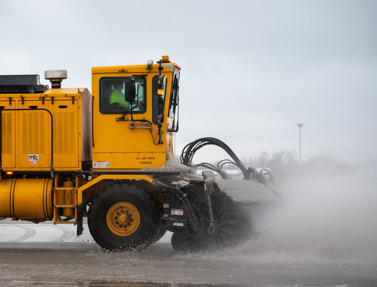 A heavy-equipment operator from the 88th Civil Engineer Group’s snow-removal team uses a brush to clear the runway at Wright-Patterson Air Force Base, Ohio, Jan. 25, 2023. The team is responsible for clearing more than 18 million square feet of concrete to keep the airfield open. (U.S. Air Force photo by Matthew Clouse)