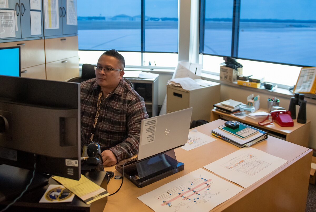 Rome Alcantara, 88th Operations Support Squadron airfield manager, works in his office overlooking the flightline at Wright-Patterson Air Force Base, Ohio, Jan. 10, 2023. His No. 1 priority is keeping the flightline open. (U.S. Air Force photo by Matthew Clouse)