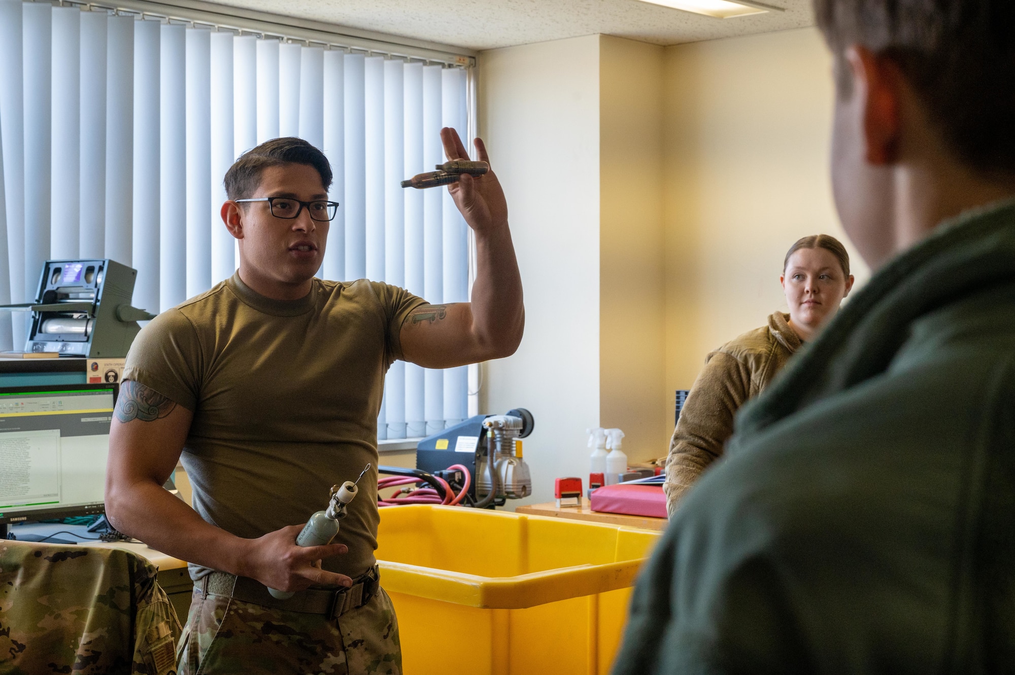 A U.S. Air Force Airman shows students different types of Aircrew Flight Equipment