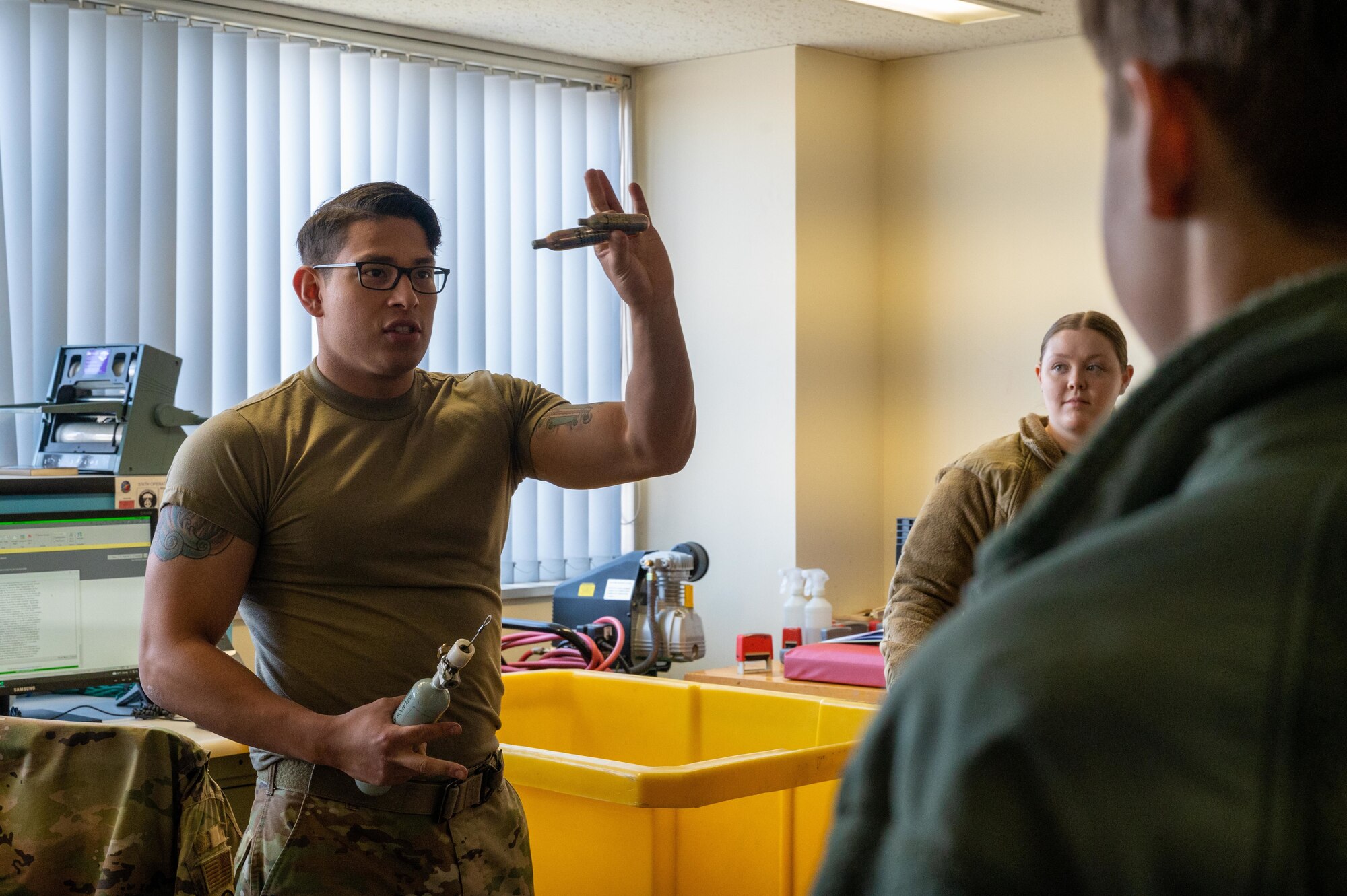 A U.S. Air Force Airman shows students different types of Aircrew Flight Equipment