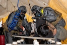 Lance Cpls. Abraham Cala, left, and Jeffrey Bravo, both assigned to the Marine Corps Chemical, Biological Incident Response Force, decontaminate a simulated casualty after removing them from an area with chemical, biological, radiological or nuclear contamination during Exercise Sudden Response 23 at Fort Hood, Texas Dec. 9, 2022.