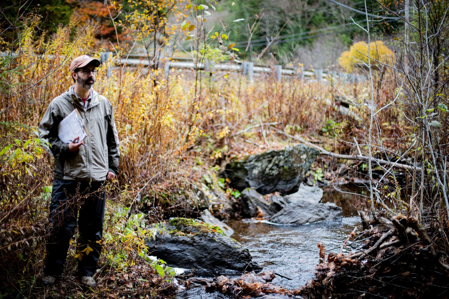 Daniel Vasconcelos, a regulator from the U.S. Army Corps of Engineers (USACE) New England District and member of the National Technical Committee for Ordinary High Watermarks (OHWM), stands along a river in Vermont while field testing an interim OHWM identification data sheet.
