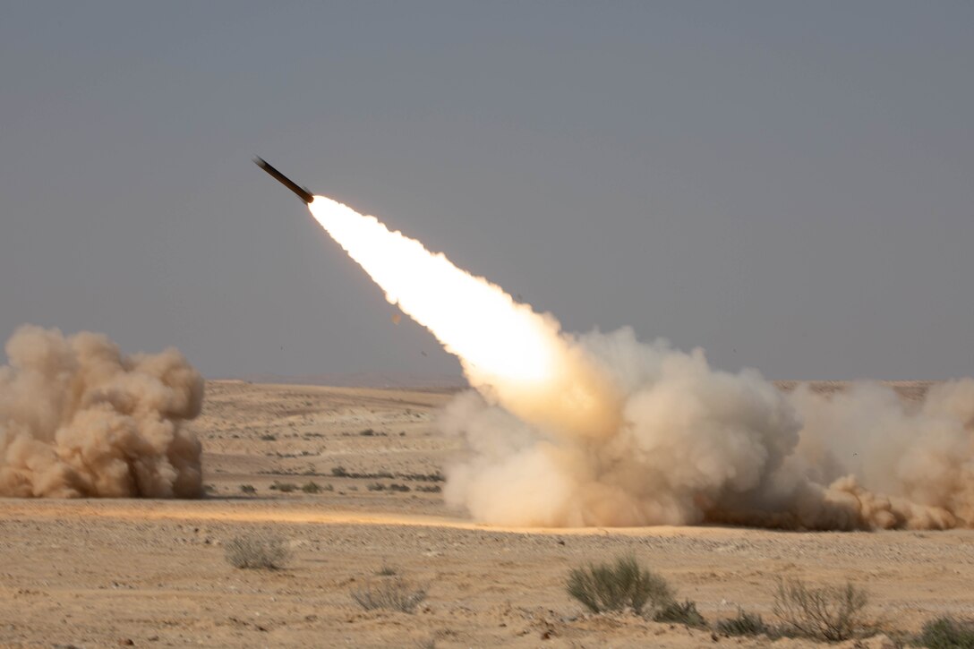 A rocket is fired from a military artillery system in the desert.