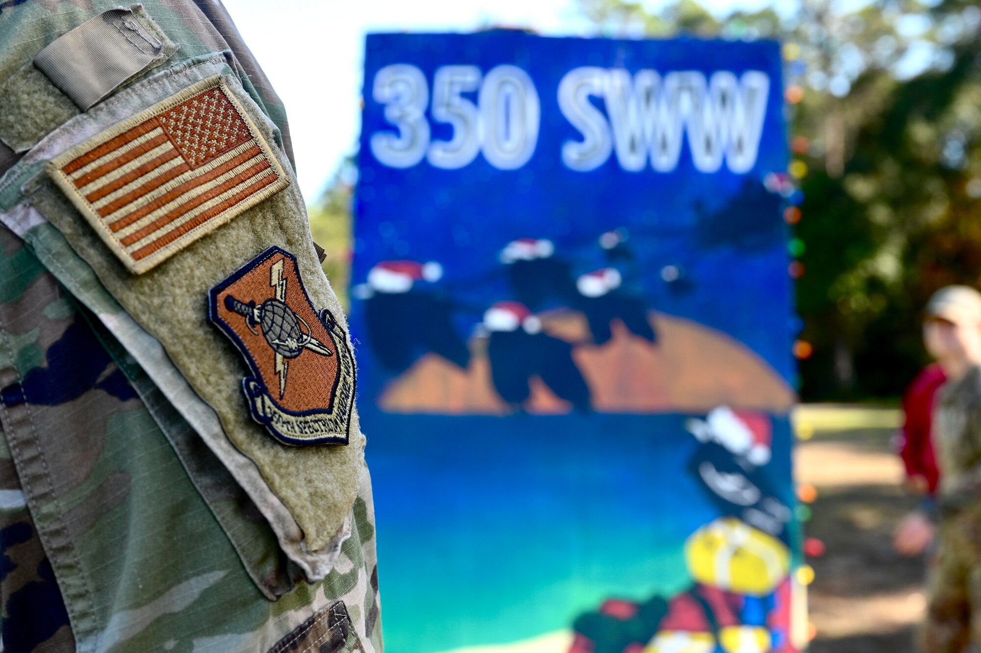 The patch of the 350th Spectrum Warfare Wing is displayed in front of the wing's holiday greeting card display at Eglin Air Force Base, Fla., Dec. 2, 2022. This year marks the 38th Annual Holiday Greeting Card Competition where all base organizations can create a giant holiday card to be displayed on Eglin boulevard. (U.S. Air Force photo by 1st Lt. Benjamin Aronson)