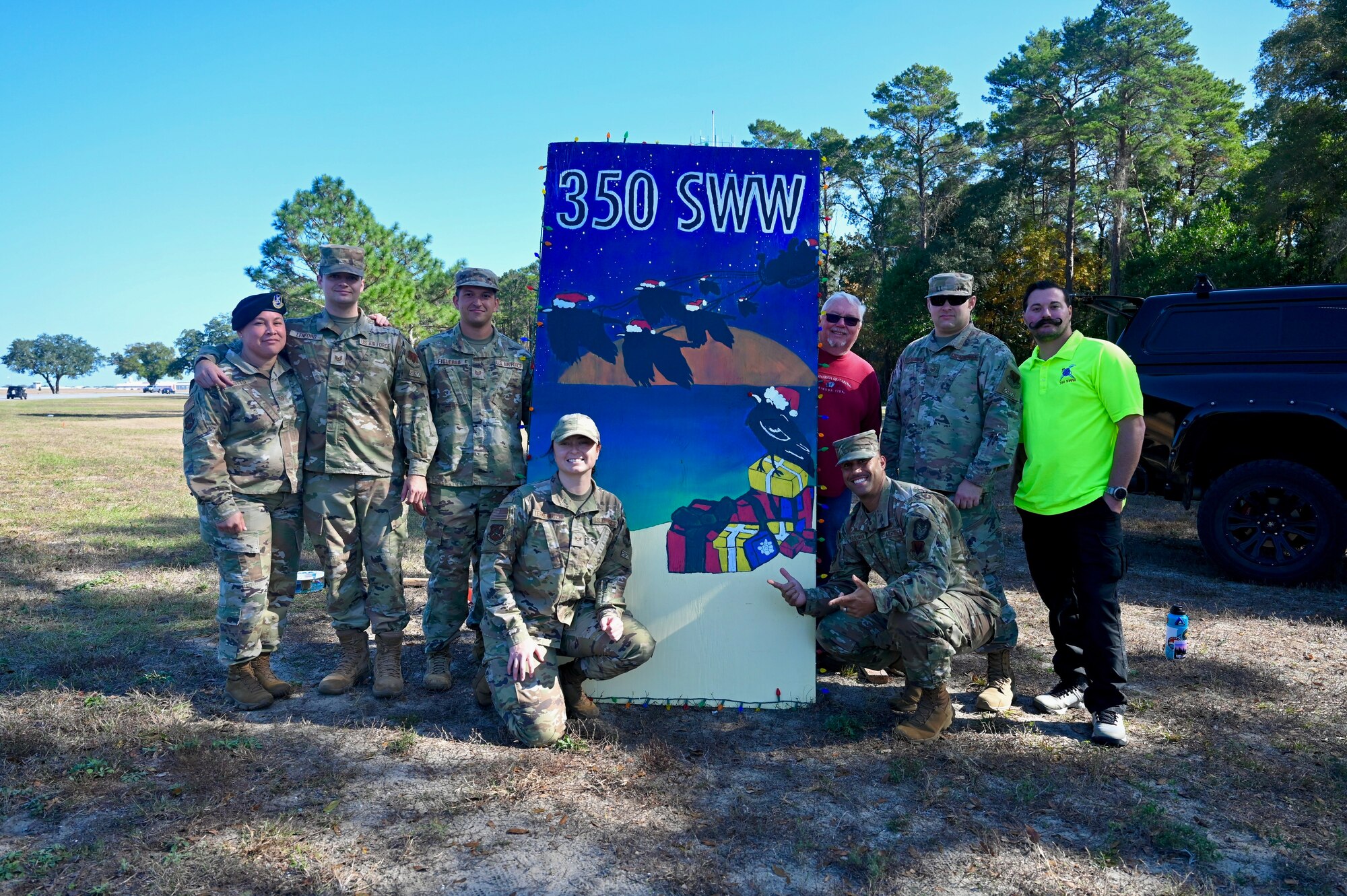 Members from the 350th Spectrum Warfare Wing's Wing Staff Agencies pose for a group photo around the wing's holiday greeting card at Eglin Air Force Base, Fla., Dec. 2, 2022. This is the 350th SWW's first year participating in the Eglin Annual Holiday Greeting Card Competition (U.S. Air Force photo by 1st Lt. Benjamin Aronson)