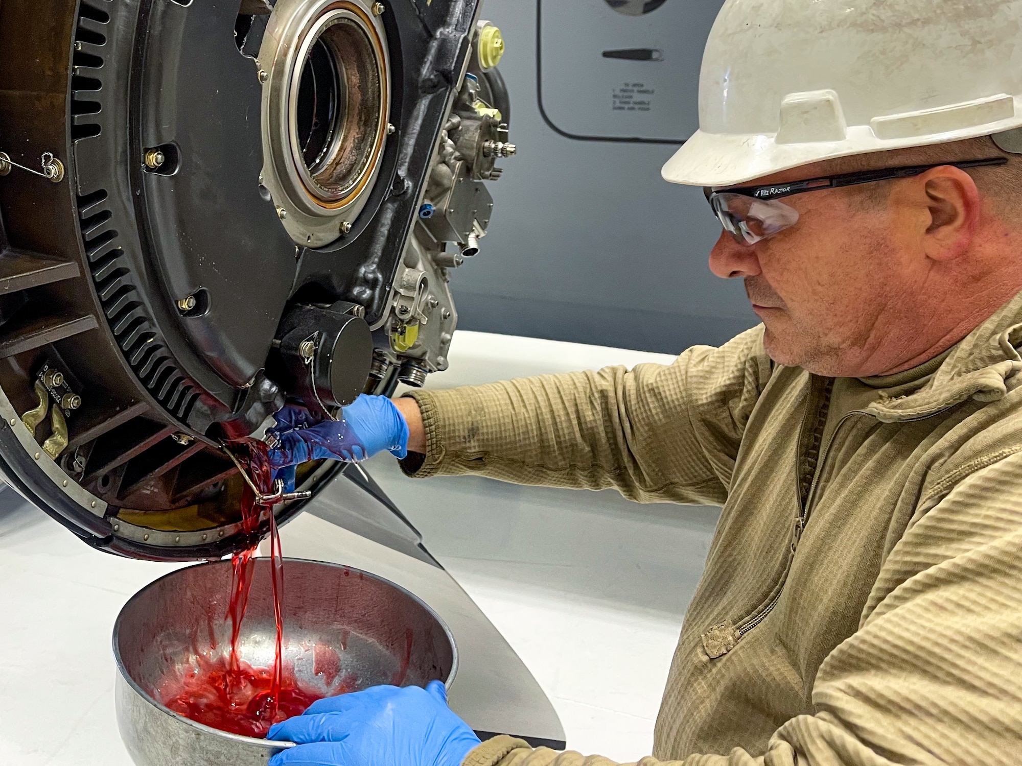 Master Sgt. Dale Cleugh, an aerospace propulsion technician with the 910th Aircraft Maintenance Squadron, drains hydraulic fluid from a C-130H Hercules propeller, Jan. 11, 2023, at Mountain Home Air Force Base, Idaho.