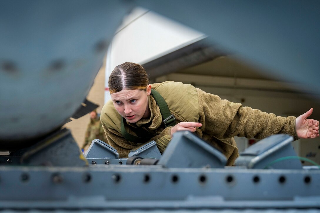 An airman guides a piece of equipment.