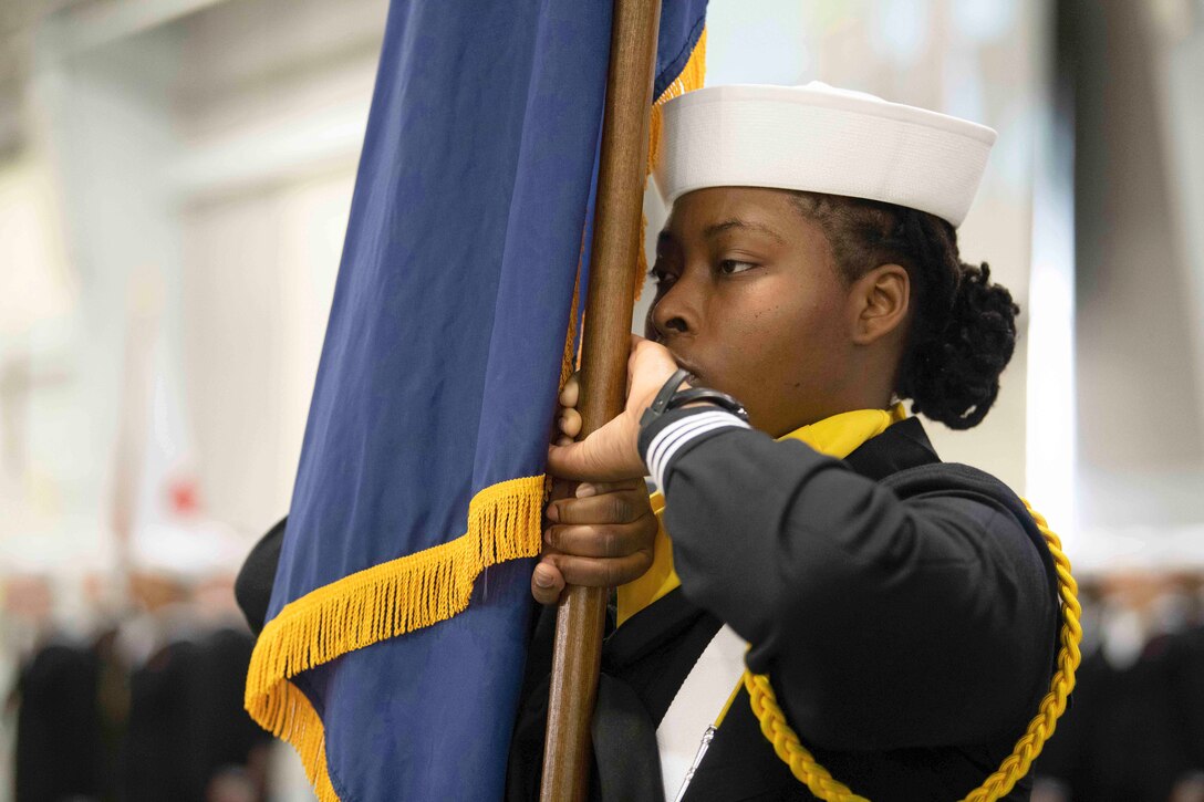 A close up shot of a sailor holding a flag.